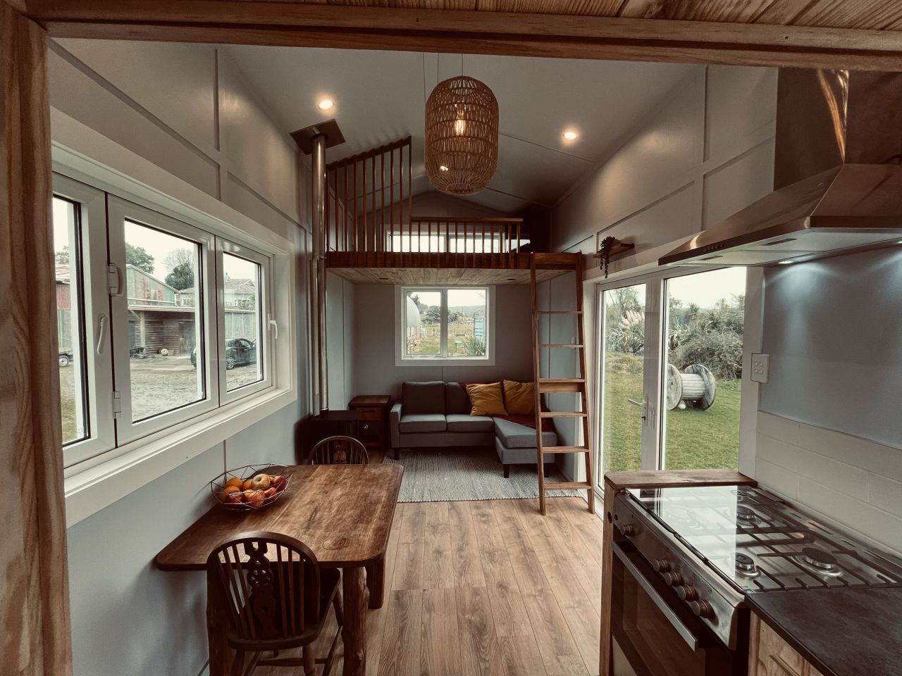 Maple Tiny House Features Overhang Shelf Above Kitchen for Extra Storage Smart Storage Hack