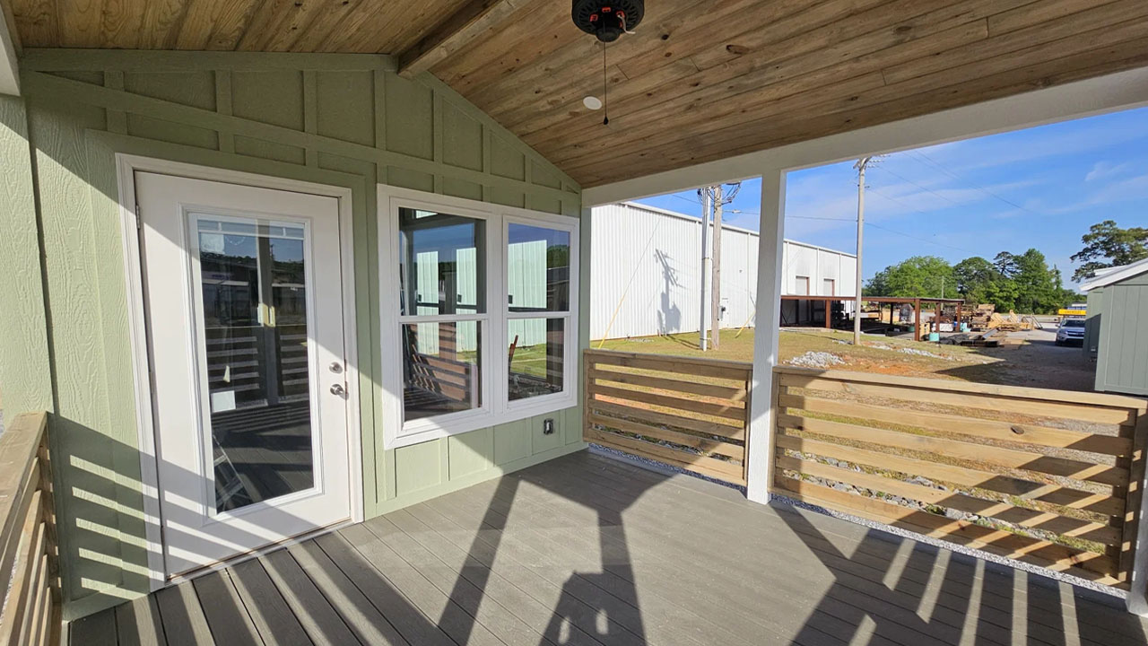 The sunlight-filled porch leads towards the entrance of Rustic Roost tiny house