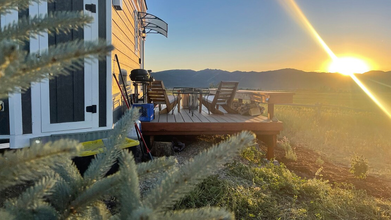 Big view tiny house_wrap-around porch with a sunset view 